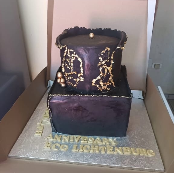 Two tier purple and black anniversary cake with gold leaf detailing